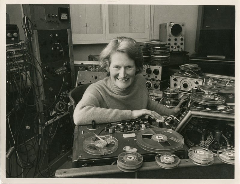 Daphne Oram at her desk, surrounded vintage sound-based technology